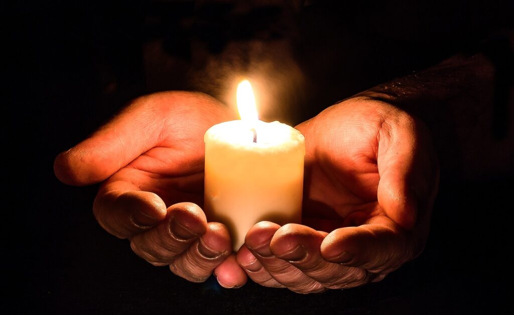 prayers hands with candles